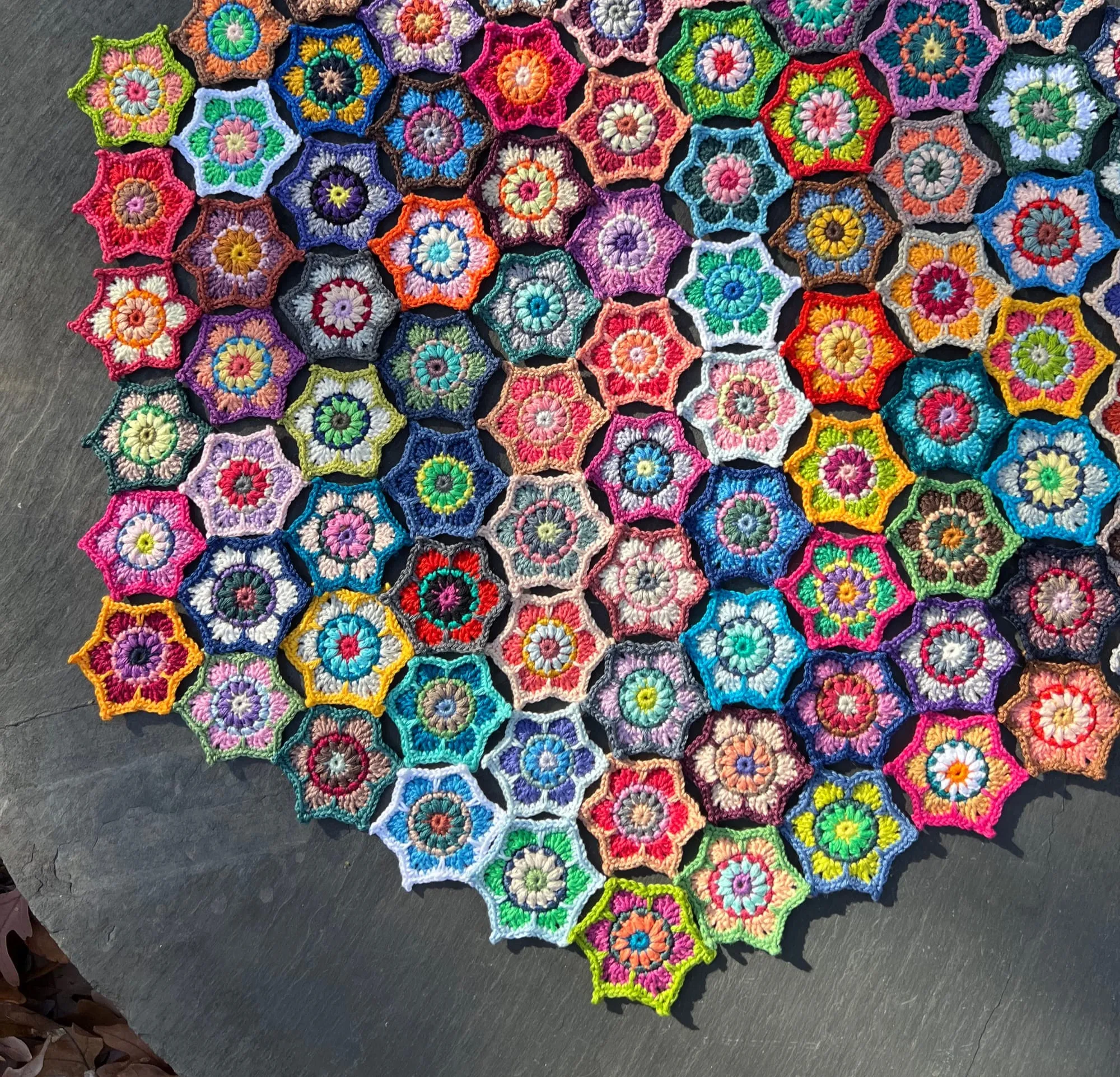A closer view of the same arrangement, showing each hexagon worked as a flower with a contrasting center and outlined in a different color.