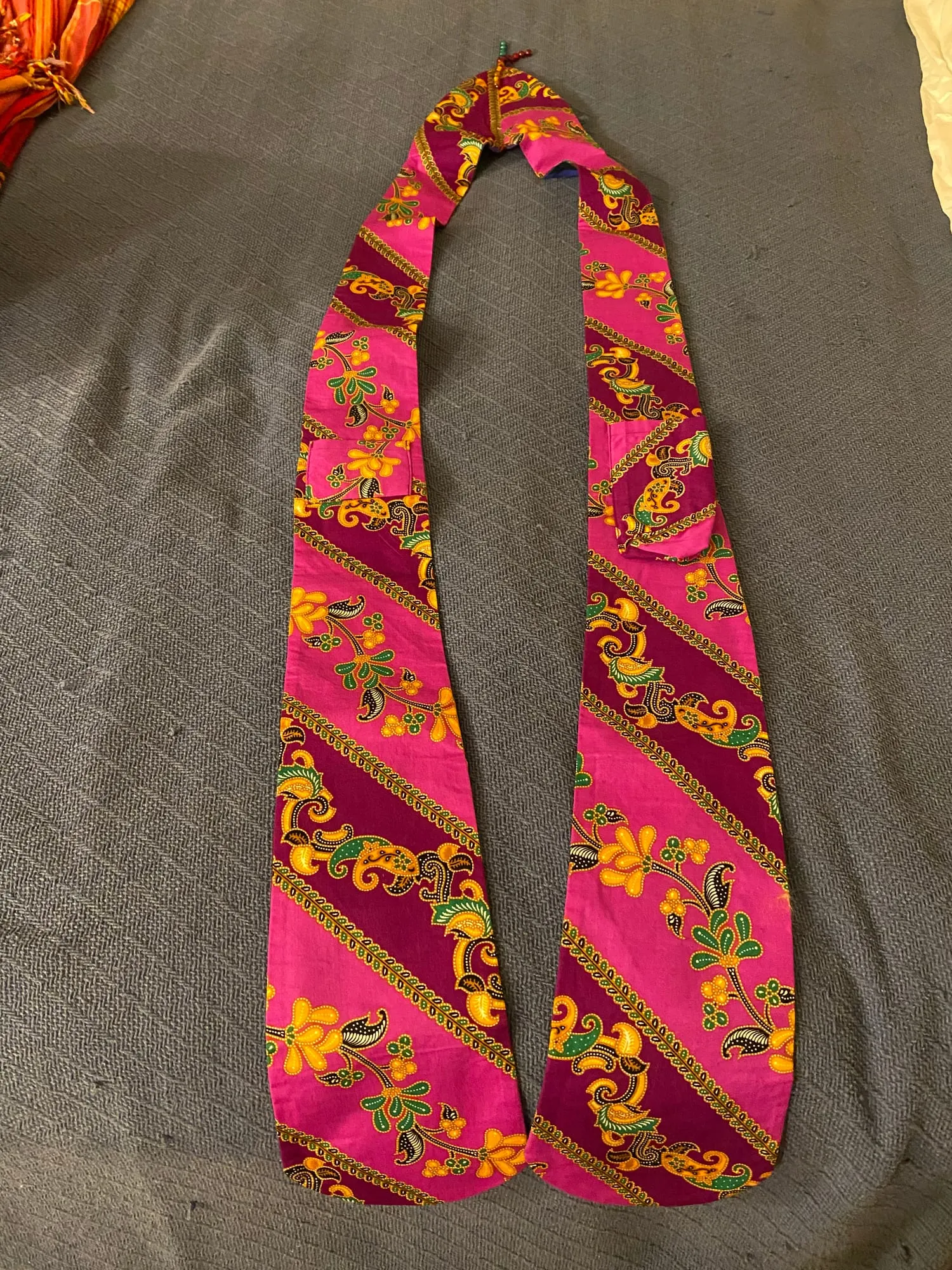 The lining of the same stole, in a bright pink and yellow floral print running in diagonal bands.